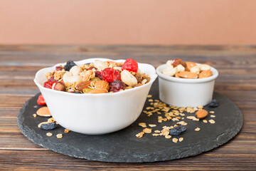 Cooking a wholesome breakfast. Granola with Various dried fruits and nuts in a bowl. The concept of a healthy dessert. Flat lay, top view with copy space