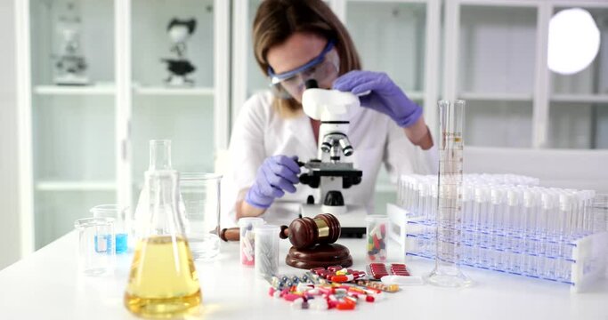 Scientist expert looks through microscope in laboratory. Check effectiveness of drugs