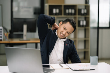 Fototapeta premium Businessman is doing a stretchy posture due to sitting in the office for too long, office syndrome concept.