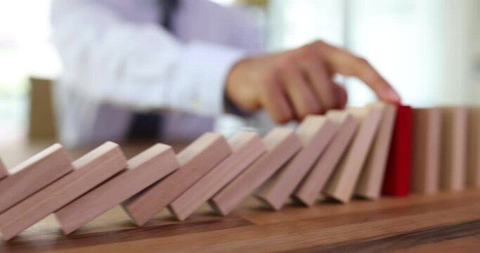 Finger stops domino effect of protection and insurance blocks. Business risk management concept. and business strategy