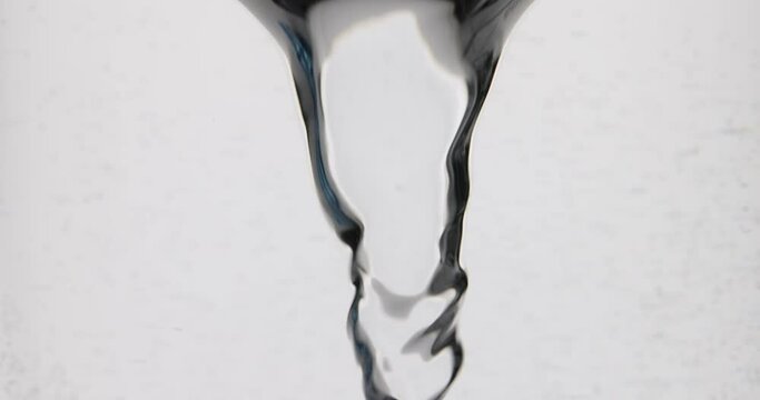 Flow of liquid water swirls into whirlpool or tornado. Fluid flow rotates and forms vortex in slow motion
