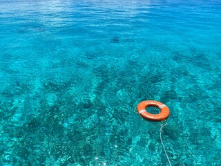 青い海に浮かぶ赤い浮き輪。 © tomoko