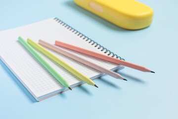 Multi-colored pencils lie on an open notebook, school supplies, back to school, preparation for school
