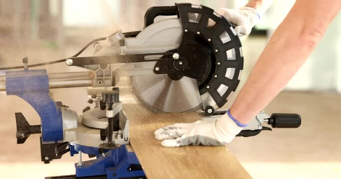 Contractor using circular saw to repair laminate cut. Flooring contractor at work cutting a piece of laminated panel with circular table saw