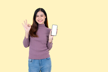 Naklejka premium A smiling Asian woman shows the Okay hand sign, holds a smartphone mockup to the camera