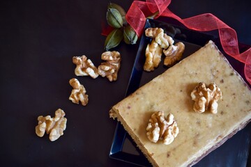 turrón de nueces y chocolate con fondo oscuro con cinta roja con enfoque selectivo
