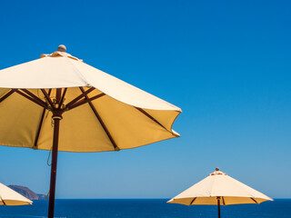Obraz na płótnie Canvas Parasoles de playa con cielo azul