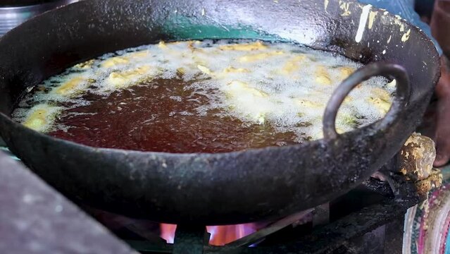 deep frying of big chili at mustered oil at street shop