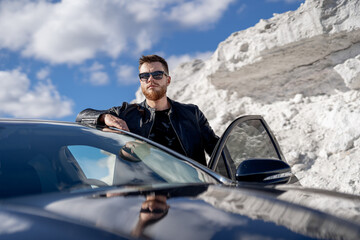 Man standing next to a car in the snow