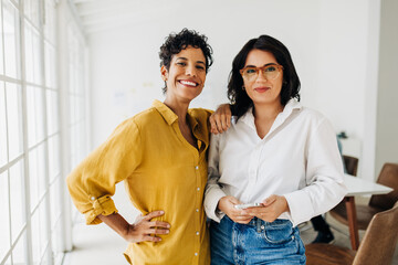 Portrait of two business women standing together in an office