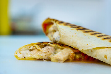 Deliciously wrapped burrito sitting on a table, ready to be devoured. A close up of a burrito on a table