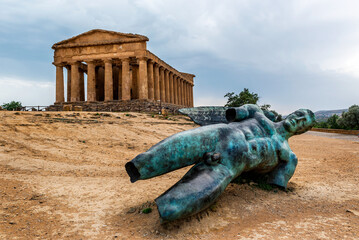 The Temple of Concordia is a Greek temple of the ancient city of Akragas, located in the Valley of the Temples of Agrigento and bronze statue of Icarus in Sicily Italy - obrazy, fototapety, plakaty