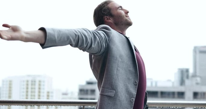Rain, freedom and business man in city with arms out for happiness, positive mindset and carefree attitude. Happy, corporate worker and male person enjoy winter weather on travel, commute and journey