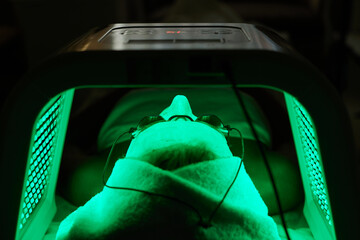 Woman getting facial treatment with led therapy.
