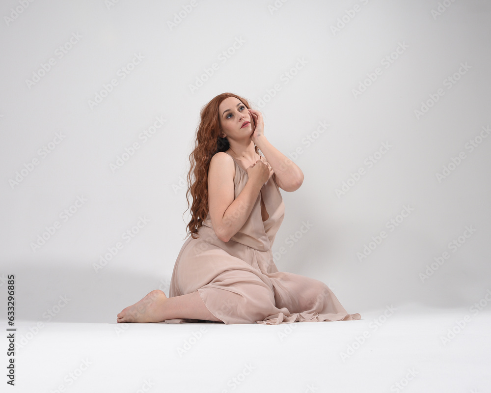 Sticker Full length portrait of beautiful brunette model  wearing a  pink dress. graceful sitting  pose, kneeling on floor gestural hands. shot from low angle perspective,  isolated on white studio background