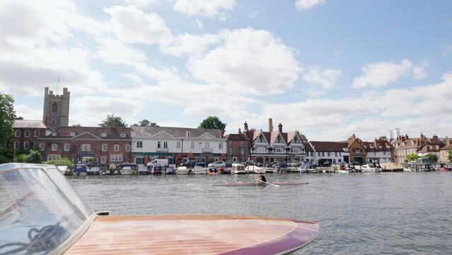 River Thames At Henley On Thames In Oxfordshire UK With Town Skyline And Rower In Foreground