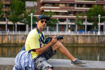 Man in Cap and Sunglasses Capturing City Moments on Camera