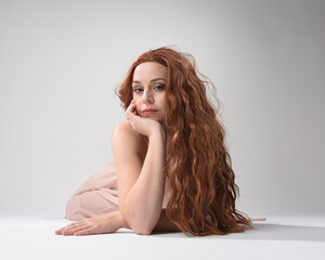 Full length portrait of beautiful brunette model  wearing a  pink dress. graceful sitting  pose,...