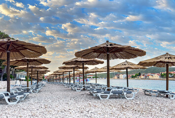 Beach with umbrellas and daybeds in the early morning.