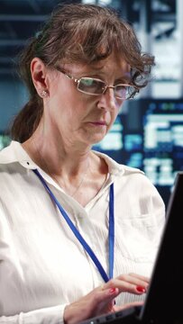 Vertical video Knowledgeable supervisor looking around advanced data center, preparing to start comission on damaged high tech blade servers in order to ensure optimal operations