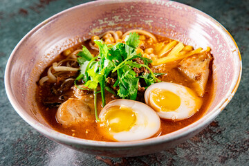Asian noodle soup, ramen with chicken, tofu, vegetables and egg in bowl