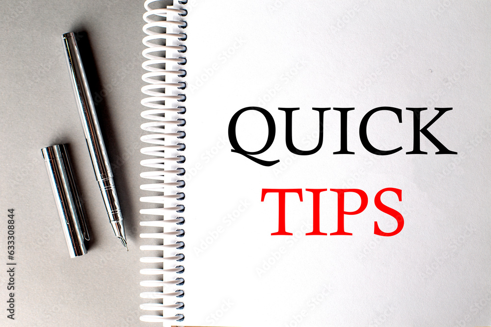 Poster quick tips text on a notebook with pen on grey background