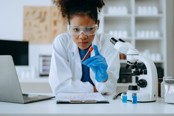Modern medical research laboratory. African female scientist working with micro pipettes analyzing...