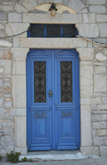 Fototapeta na wymiar Old Greek Home with Blue Door and Lamp in Symi, Greece