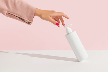 Womans hands with lotion or cream on pink background. Body care beauty treatment concept
