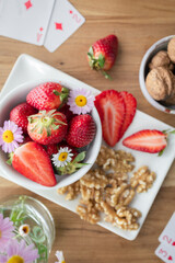 Healthy breakfast or snack with fresh strawberries, walnuts and daisies