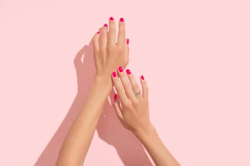 Deurstickers Schoonheidssalon Womans hands with pink nail design. Manicure, pedicure beauty salon concept. Deep long shadows.