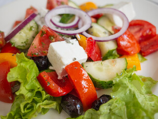 fresh salad with onion, tomato, cheese on the white plate in tatar restaurant in capital kyiv