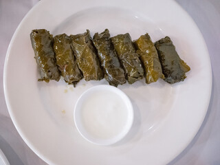 grape leaves cuisine with sour cream on the white plate in tatar restaurant in capital kyiv 
