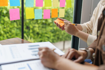 Business People working on sticky notes creative writing down ideas on post it notes professional investor start up project business.