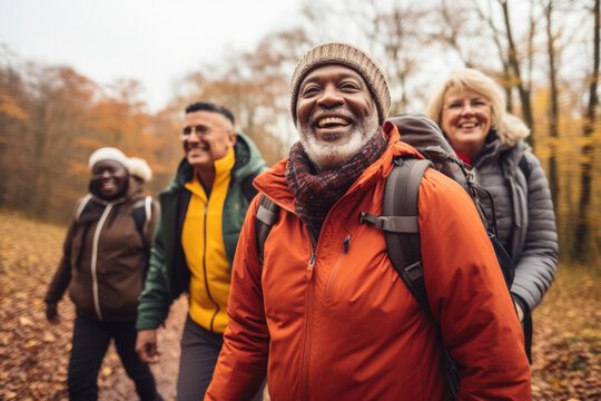 Diverse group of active senior people walking outdoors hiking in autumn park.