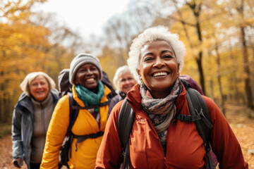 Group of active seniors tourists walking in autumn forest or park together.