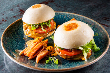 two Bao delicious chicken burger with meat, cheese and vegetablea on plate