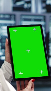 Vertical video Octogenarian specialist in servers workspace housing high end processors capable of quickly and efficiently performing complex computations and data analysis, using mockup tablet to