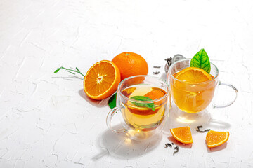 Orange tea in glass cups with ripe fruits. Refreshment seasonal drink, conceptual background