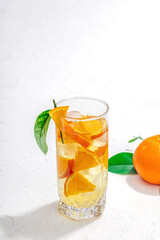 Orange cocktail with ice and ripe fruits. Refreshment seasonal drink, conceptual background