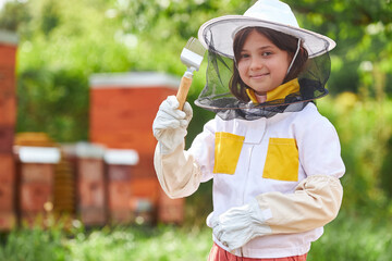 Portrait of girl examining hive fork at apiary garden