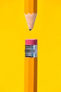 Sharpened broken tip and eraser at top pencils placed together on yellow backdrop