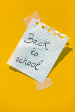 Note with message back to school pasted on yellow wall