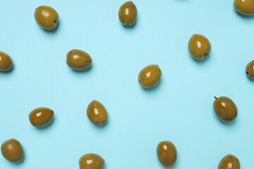 Green olives on blue background, top view