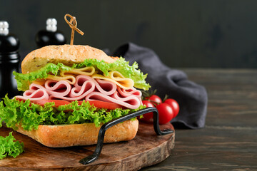 Sandwich. Tasty sandwich with ham or bacon, cheese, tomatoes, lettuce and grain bread on dark...