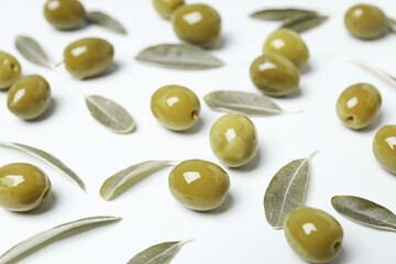 Olives and tree leaves on white background, close up