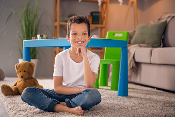 Photo of cute adorable preschool boy sitting floor in nursery room playing with many toys comfort...