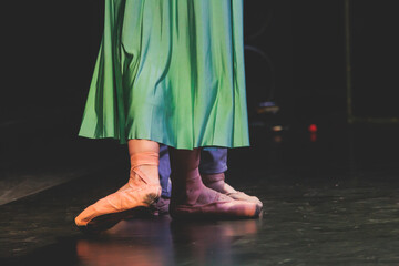 Ballet dancers couple during performance repetition, classic ballet rehearsal practicing in ballroom, view of legs in pointe shoes, ballerina and ballet dancer on a concert hall theatre stage © tsuguliev