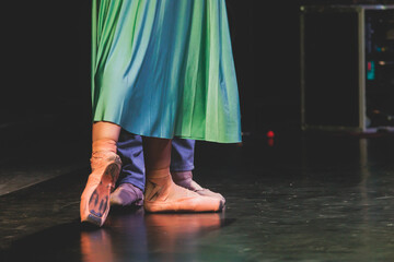 Ballet dancers couple during performance repetition, classic ballet rehearsal practicing in ballroom, view of legs in pointe shoes, ballerina and ballet dancer on a concert hall theatre stage © tsuguliev