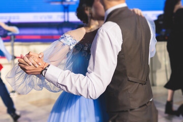 High school graduates dancing waltz and classical ball dance in dresses and suits on school prom...